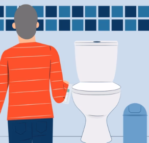 Man standing in front of toilet holding bowel test kit